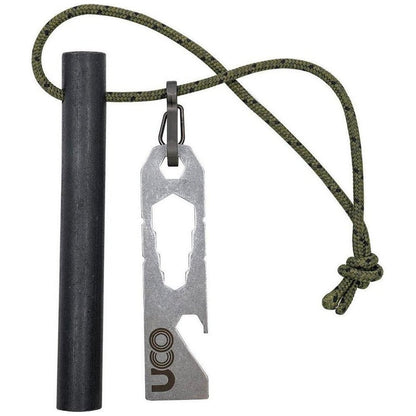 A charcoal ferro rod and UCO Titan Fire Striker hang from a green paracord against a white background.