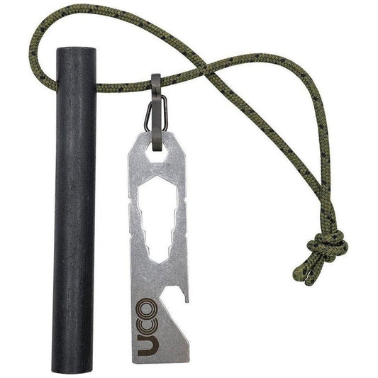A charcoal ferro rod and UCO Titan Fire Striker hang from a green paracord against a white background.