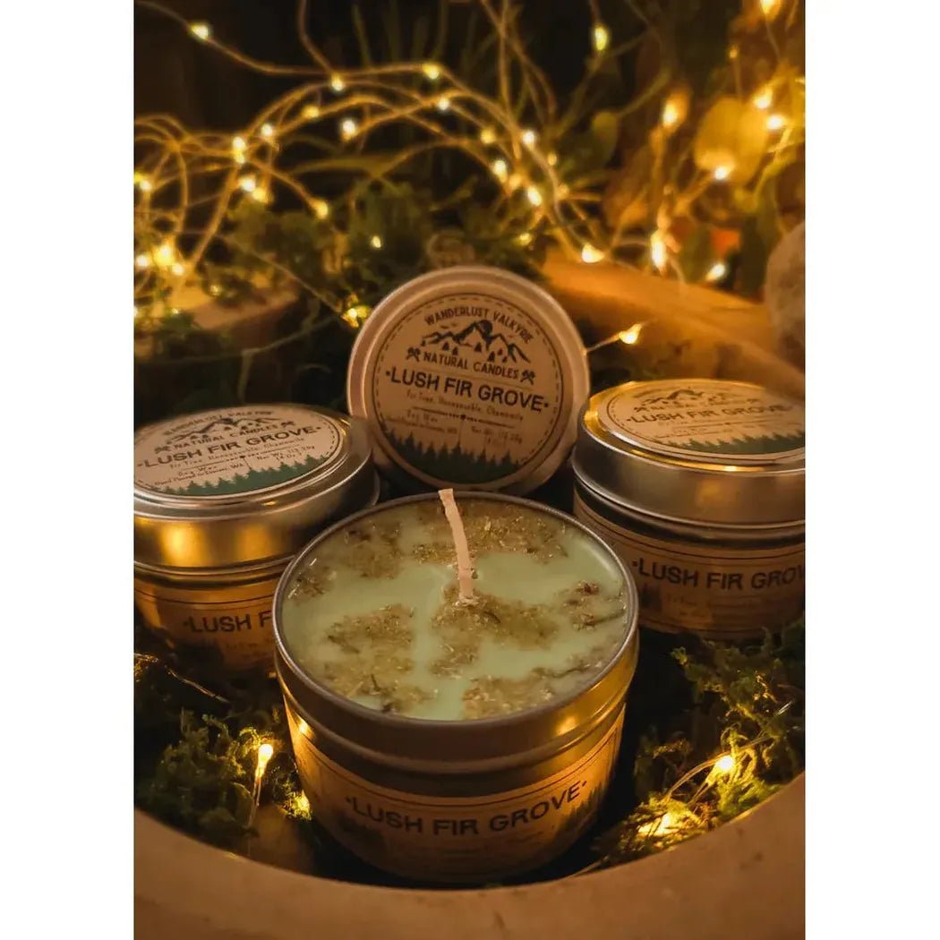 A close-up of Wanderlust Folk Lush Fir Grove 4 oz candles in a wooden bowl with fairy lights in the background.
