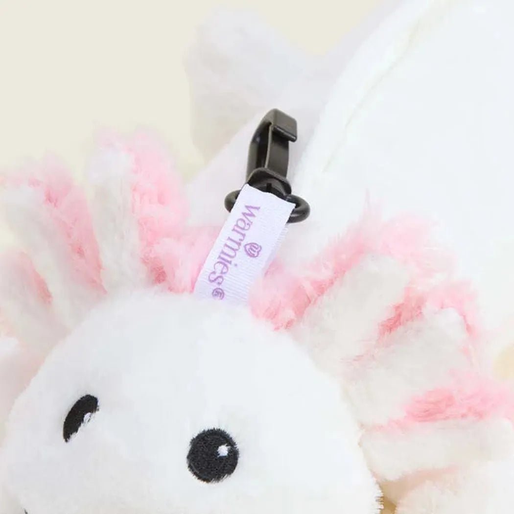 A close-up of the Warmies Axolotl Bag Charm showing its pink and white fur and black eyes.