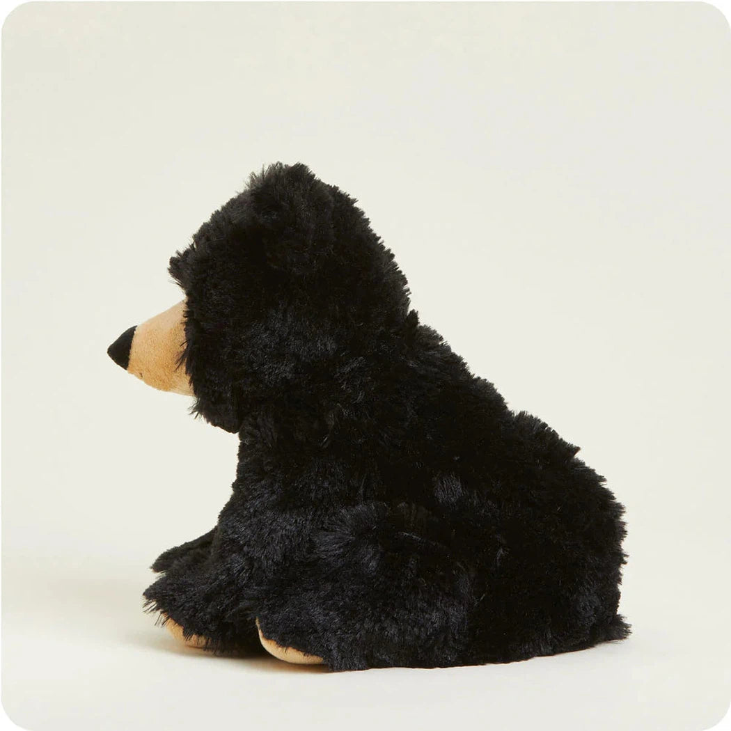 Side view of the Warmies Bear plush toy with black fur and tan accents against a plain white background.
