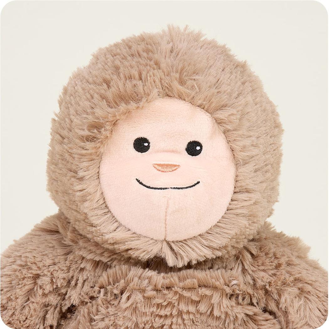 A close-up of the Warmies BigFoot plush toy showing its soft brown fur and friendly face against a plain white background.