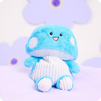 A front view of the Warmies Blue Mushroom plush toy showing its smiling face and white ribbed belly against a light purple background.