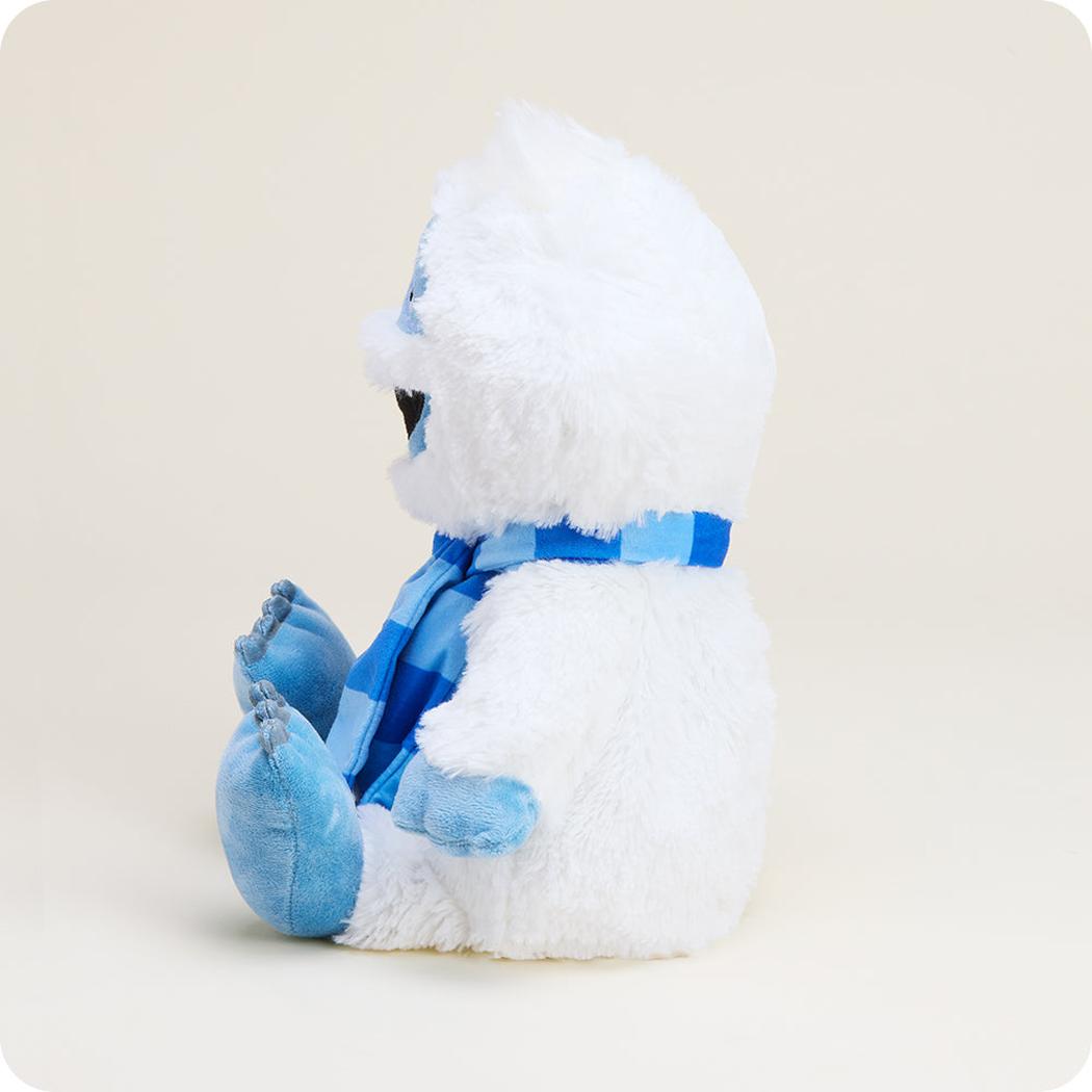 Side view of the Warmies Bumble With Scarf showing the blue scarf and white fur against a light background.