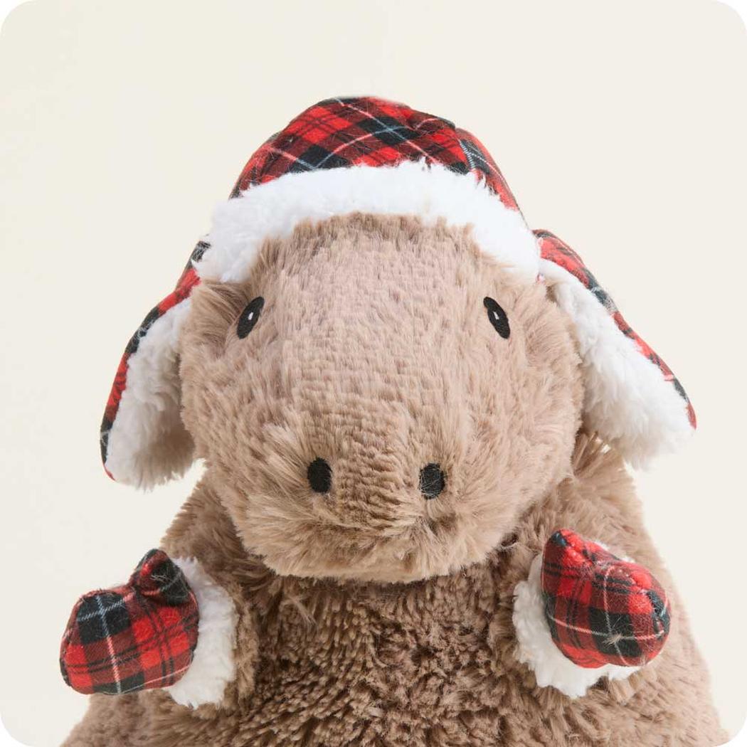 A front view of the Warmies Cozy Capybara wearing a red and black plaid Santa hat with white trim against a light background.