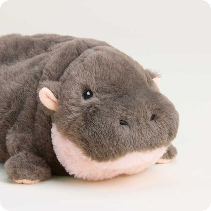 A close-up of the Warmies Hippo plush toy with a soft, light background.