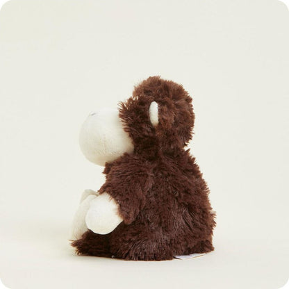 A side view of the Warmies Monkey Junior plush toy with brown fur and white face and hands against a plain white background.