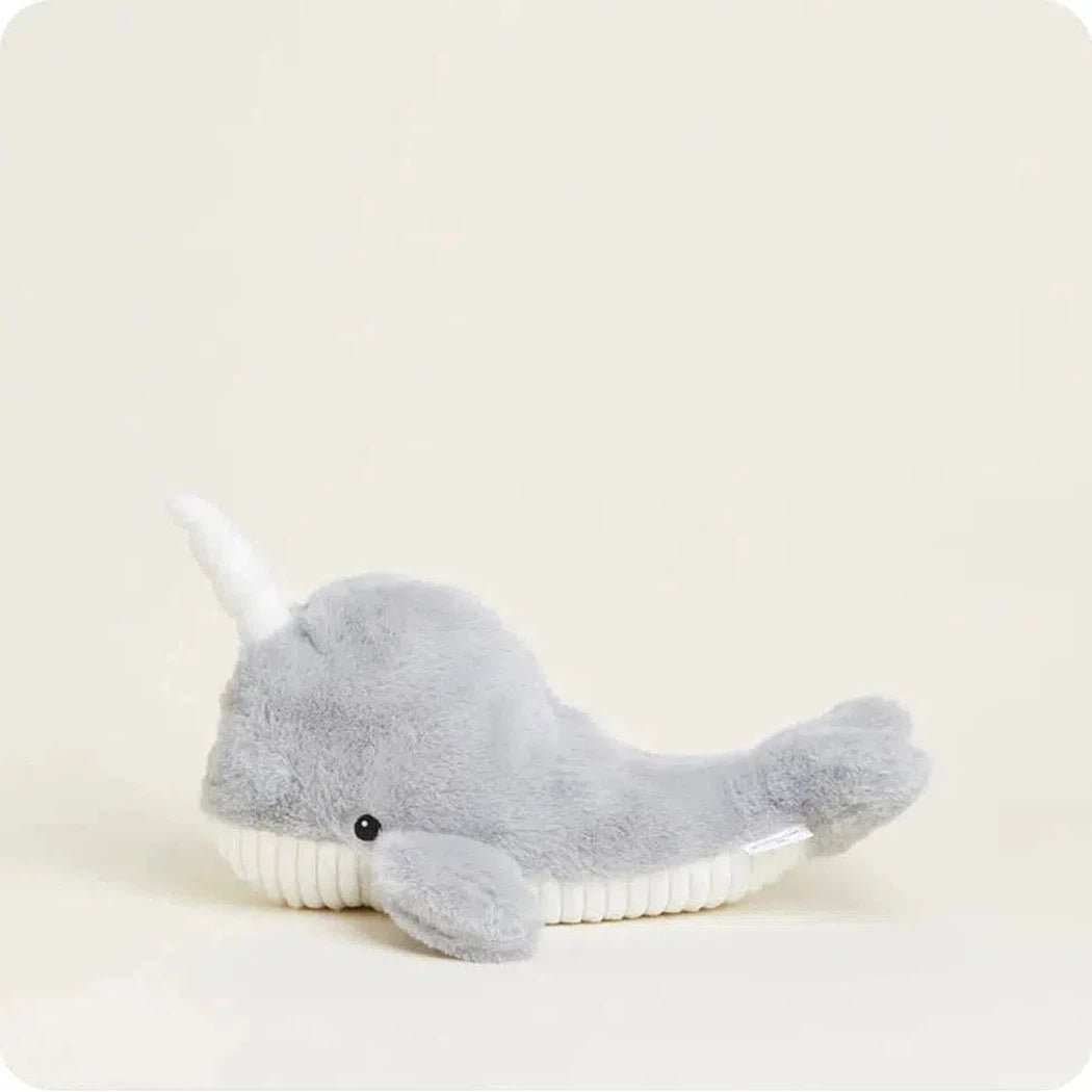 A side view of the Warmies Narwhal plush toy with a white tusk and black eye against a plain light background.