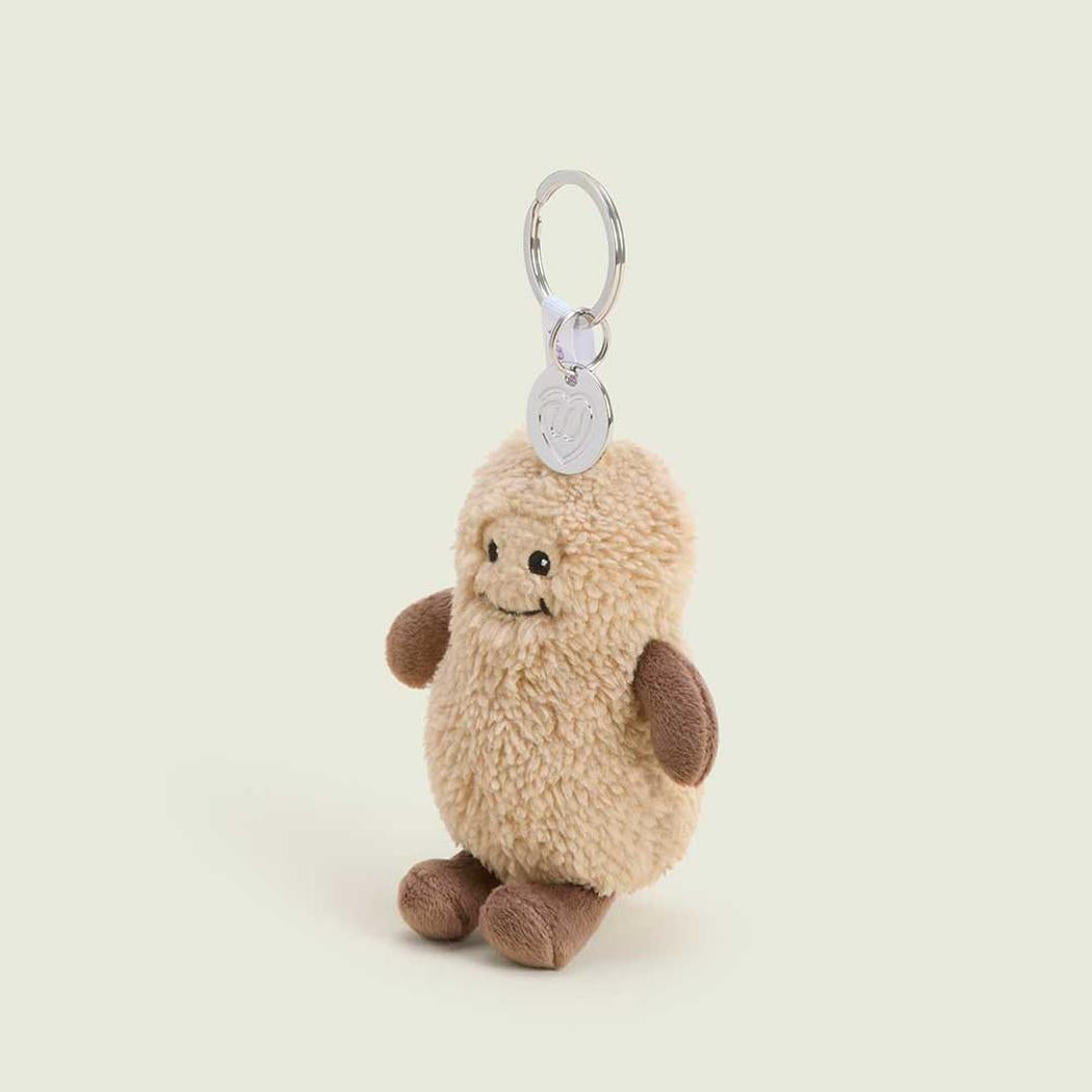 A front view of the Warmies Peanut Keyring with a light beige plush body and brown arms/legs, hanging from a silver keyring against a plain light background.