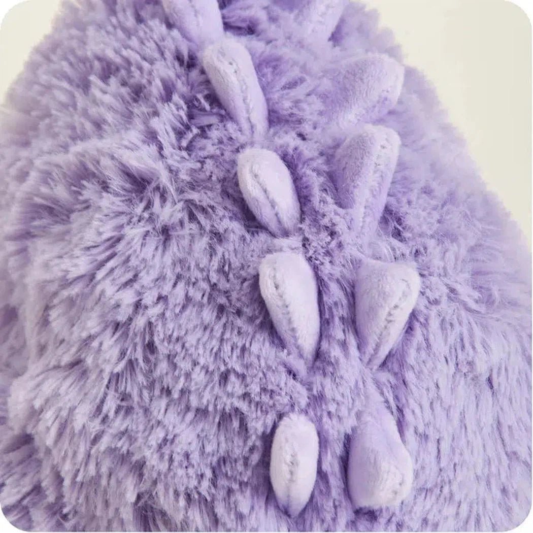 Close-up of the Warmies Purple Long Neck Dinosaur showing its fuzzy texture and spiky back against a light background.
