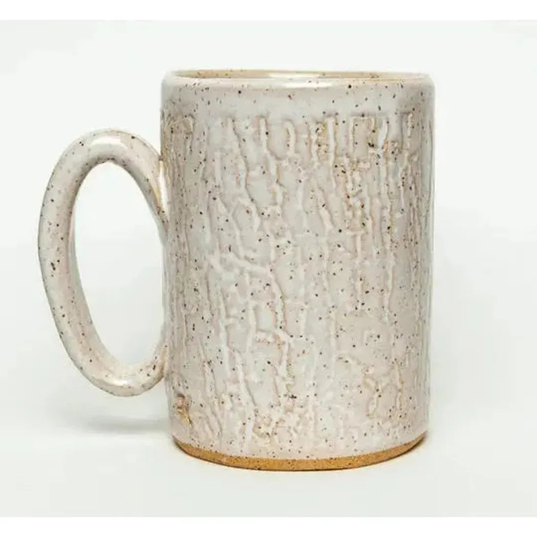 A side view of the White Squirrel Clayworks Sasquatch mug showing its textured surface and speckled glaze against a plain white background.
