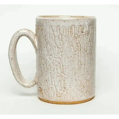A side view of the White Squirrel Clayworks Sasquatch mug showing its textured surface and speckled glaze against a plain white background.