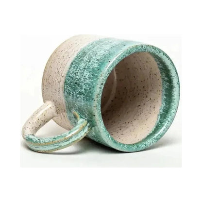 A side view of the White Squirrel Clayworks Turquoise Hand-Thrown Ceramic 12-14 oz Mug showing the turquoise rim and speckled interior against a white background.