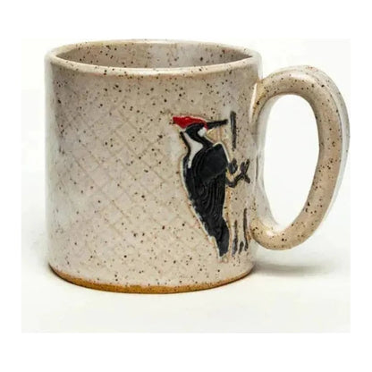 A front view of the White Squirrel Clayworks Woodpecker Design Handmade, in Ohio, Ceramic White 10oz Mug showing the woodpecker design on the side.