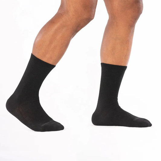 Side view of the Wide Open Men's Solid Lightweight Crew Socks in Black on a model against a white background.