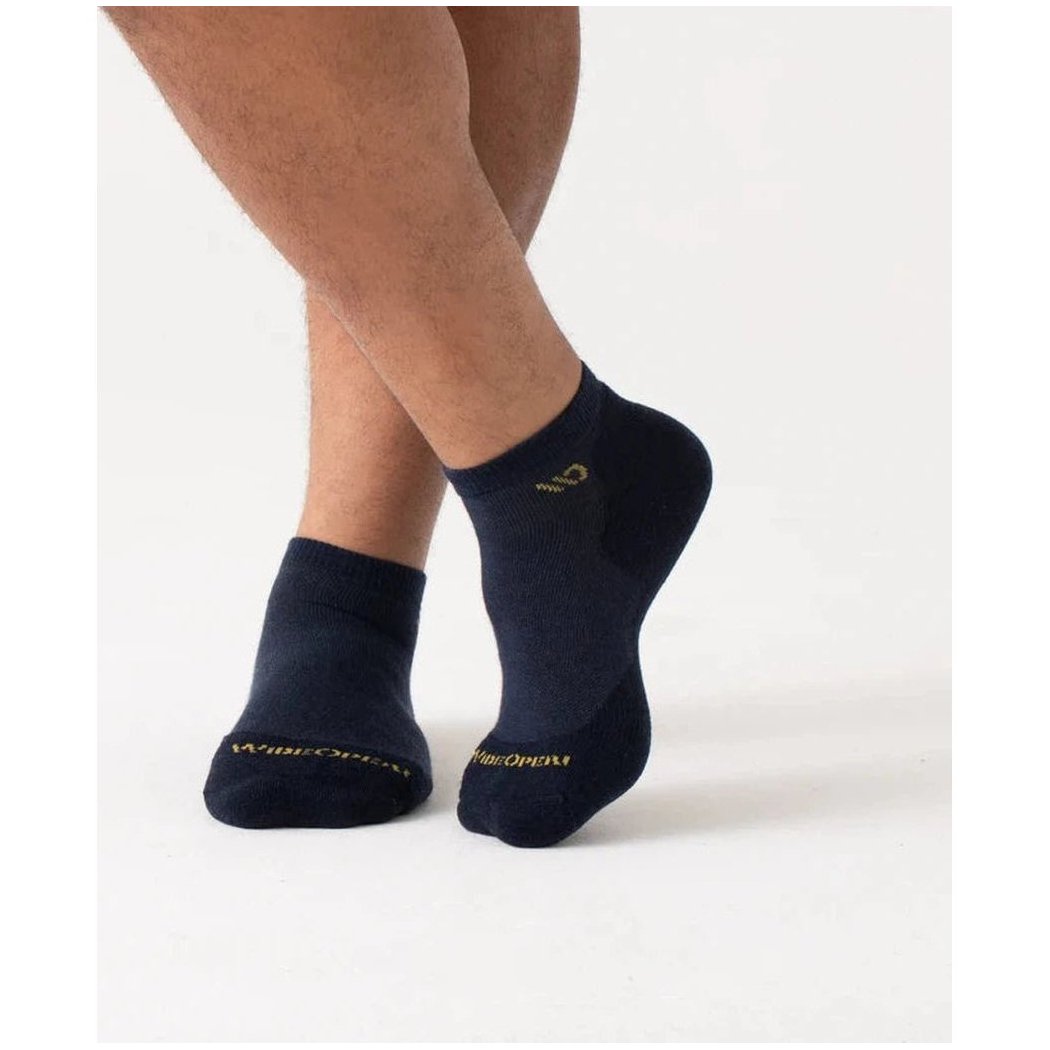 A side view of the Wide Open Men's Solid Midweight No Show Sock in Denim on a model against a white background.