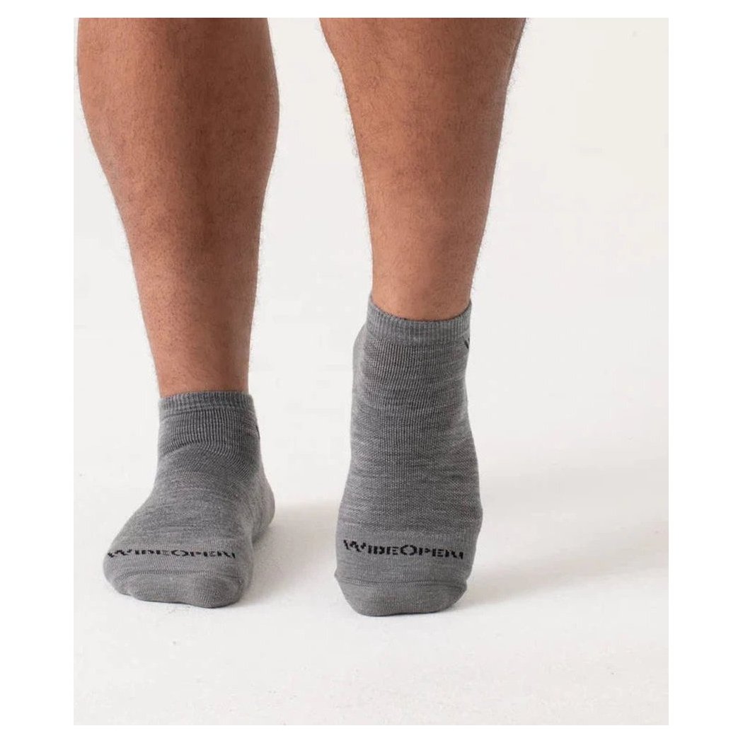 Back view of Wide Open Men's Solid Midweight No Show Sock in Denim on a model's feet against a white background.
