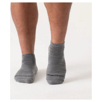 Back view of Wide Open Men's Solid Midweight No Show Sock in Denim on a model's feet against a white background.