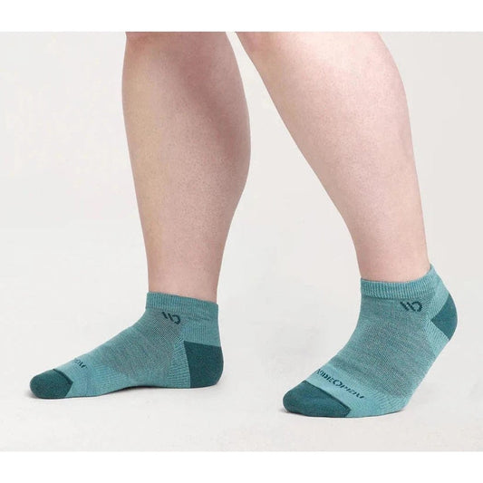 Side view of the Wide Open Women's Solid Midweight No Show Sock in Charcoal on a model's feet against a white background.