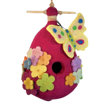 A pink Wild Woolies Butterfly Birdhouse with colorful felt flowers and a yellow butterfly, hanging from a wooden rod.