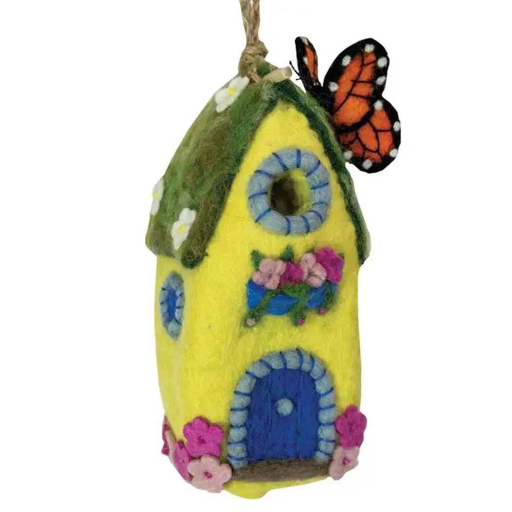 A yellow Wild Woolies Monarch Cottage Birdhouse with a green roof and orange butterfly hangs from a string.