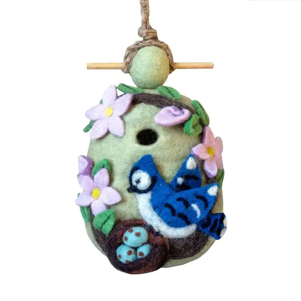 A hanging Wild Woolies Nesing Bluejay Birdhouse with a blue bird and pink flowers, shown from the front against a white background.