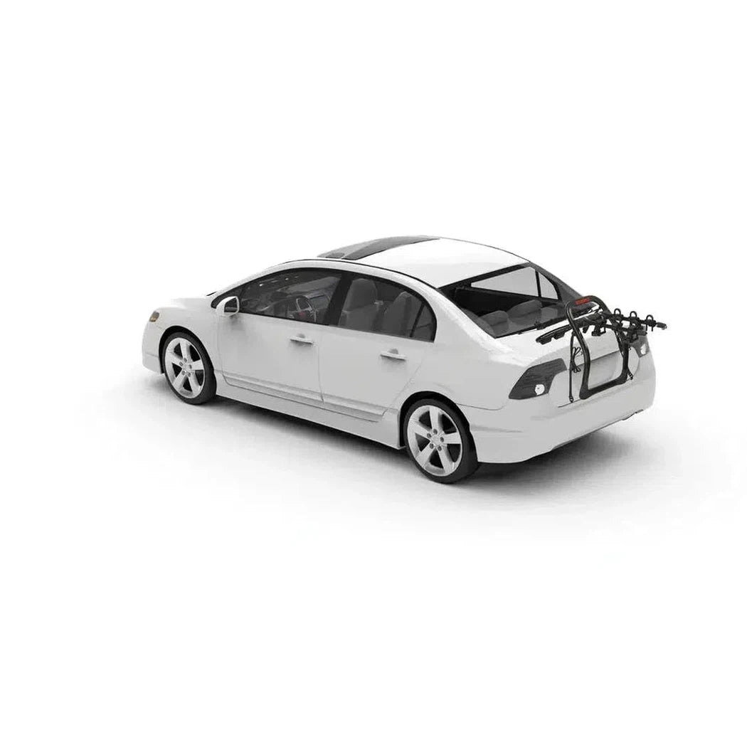 A white sedan with a Yakima FullBack bike rack mounted on its rear, photographed from a three-quarter angle against a plain white background.