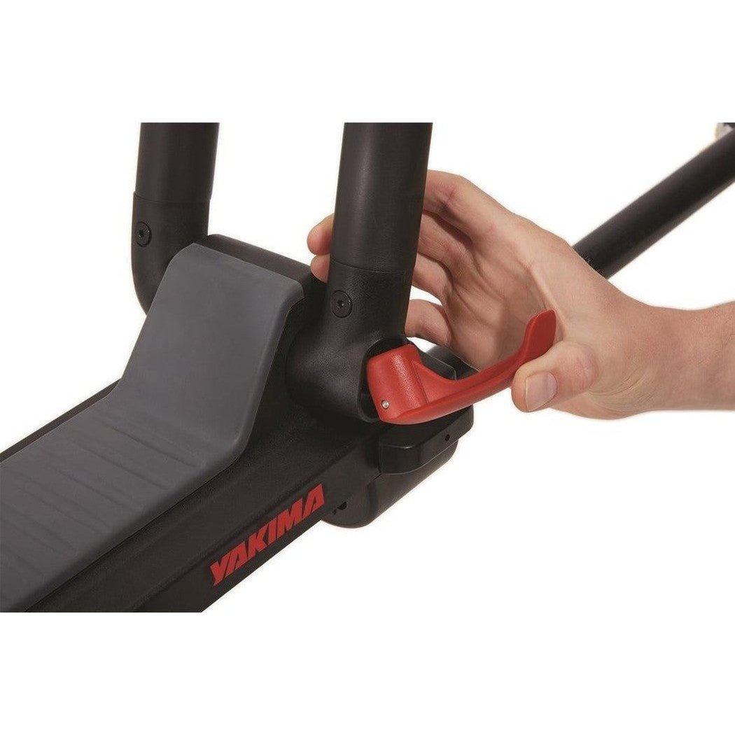 A hand adjusts the red lever on the Yakima JayLow car rack against a white background.