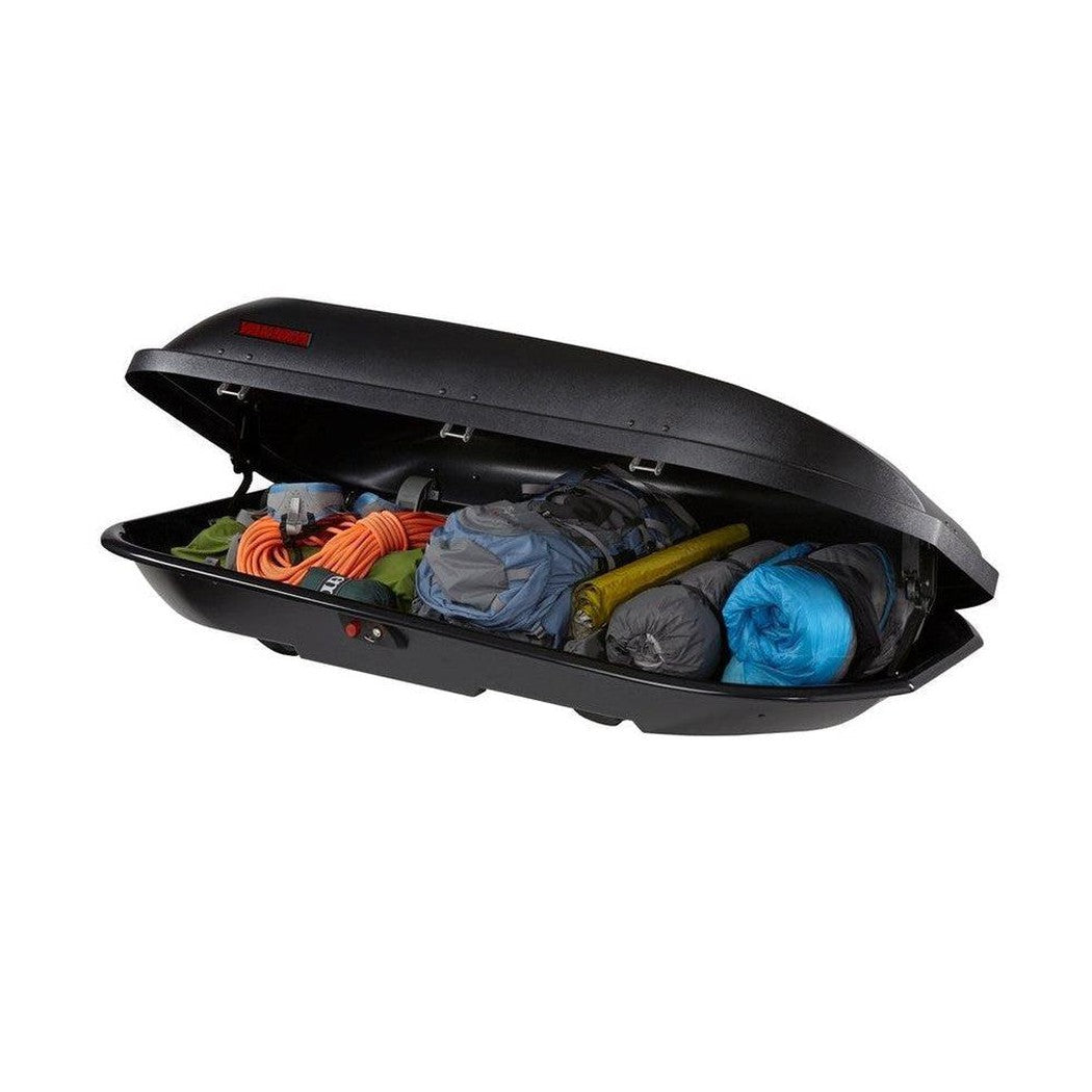 A black Yakima Rocketbox Pro 14 cargo box open to show gear like a blue sleeping bag and orange rope inside.