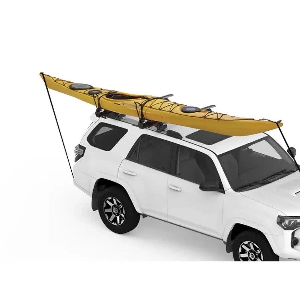 A white SUV with a yellow Yakima Showdown kayak mounted on its roof rack, photographed from a slightly angled front view against a plain white background.
